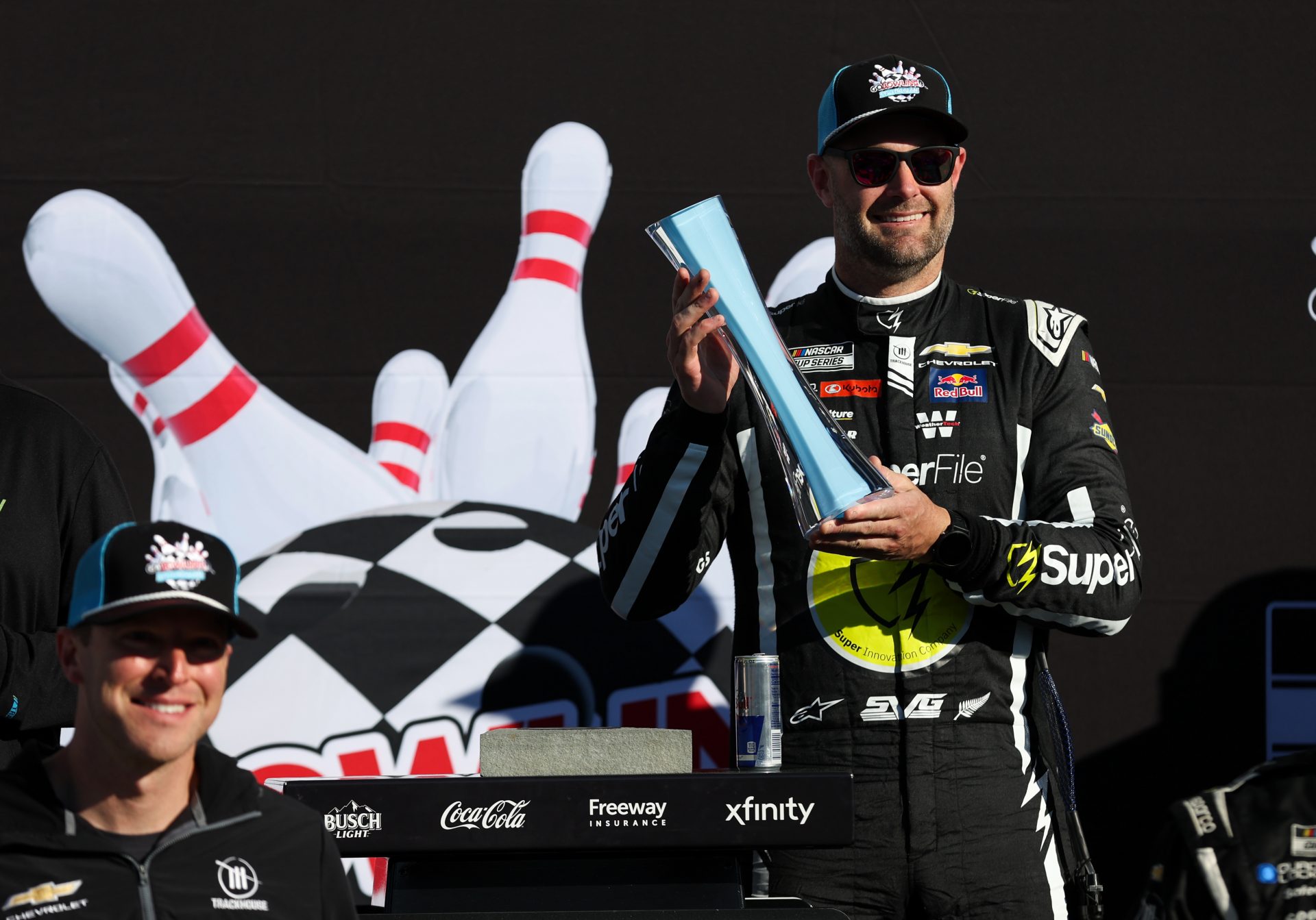 NASCAR Cup Series driver Shane Van Gisbergen raises the winner’s trophy in victory lane after winning the Go Bowling at The Glen at Watkins Glen International.