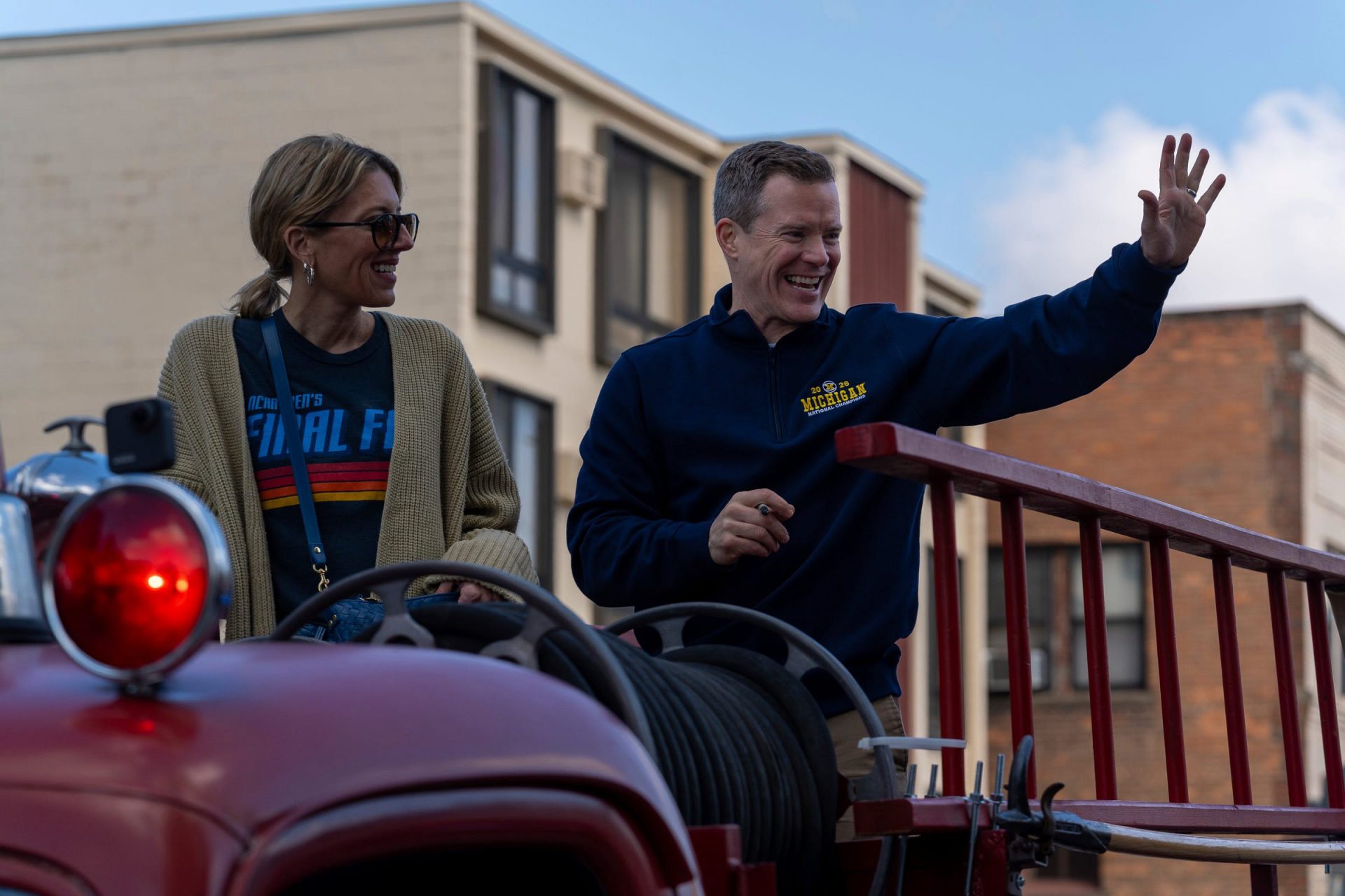 Dusty May, head coach of the University of Michigan men’s basketball team, waves to fans alongside his wife, Anna May, while riding in a parade honoring the team’s NCAA national championship in Ann Arbor on Saturday, April 11, 2026. Credit: Imagn