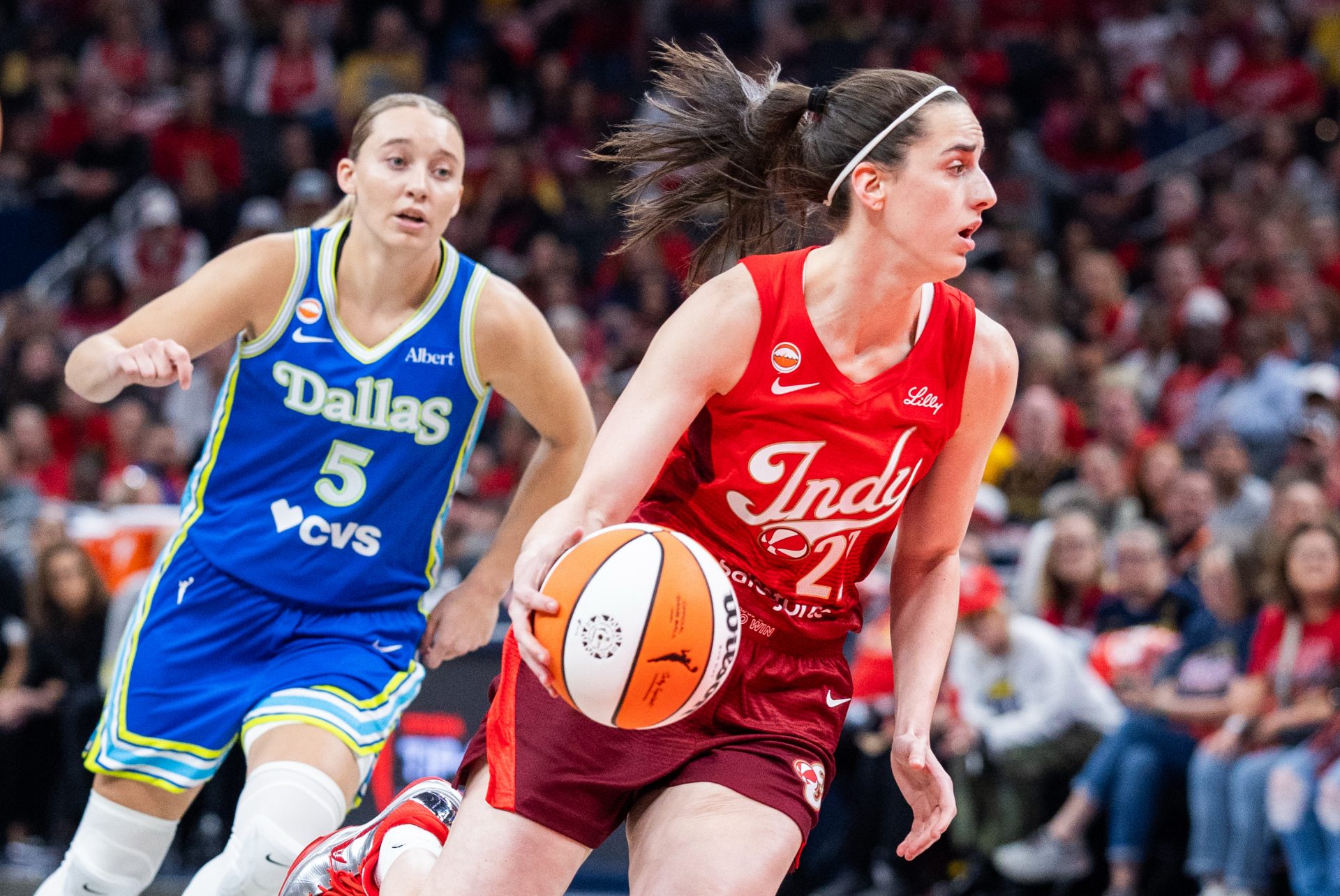 Indiana Fever guard Caitlin Clark (22) dribbles the ball while Dallas Wings guard Paige Bueckers (5) defends in the first half at Gainbridge Fieldhouse.