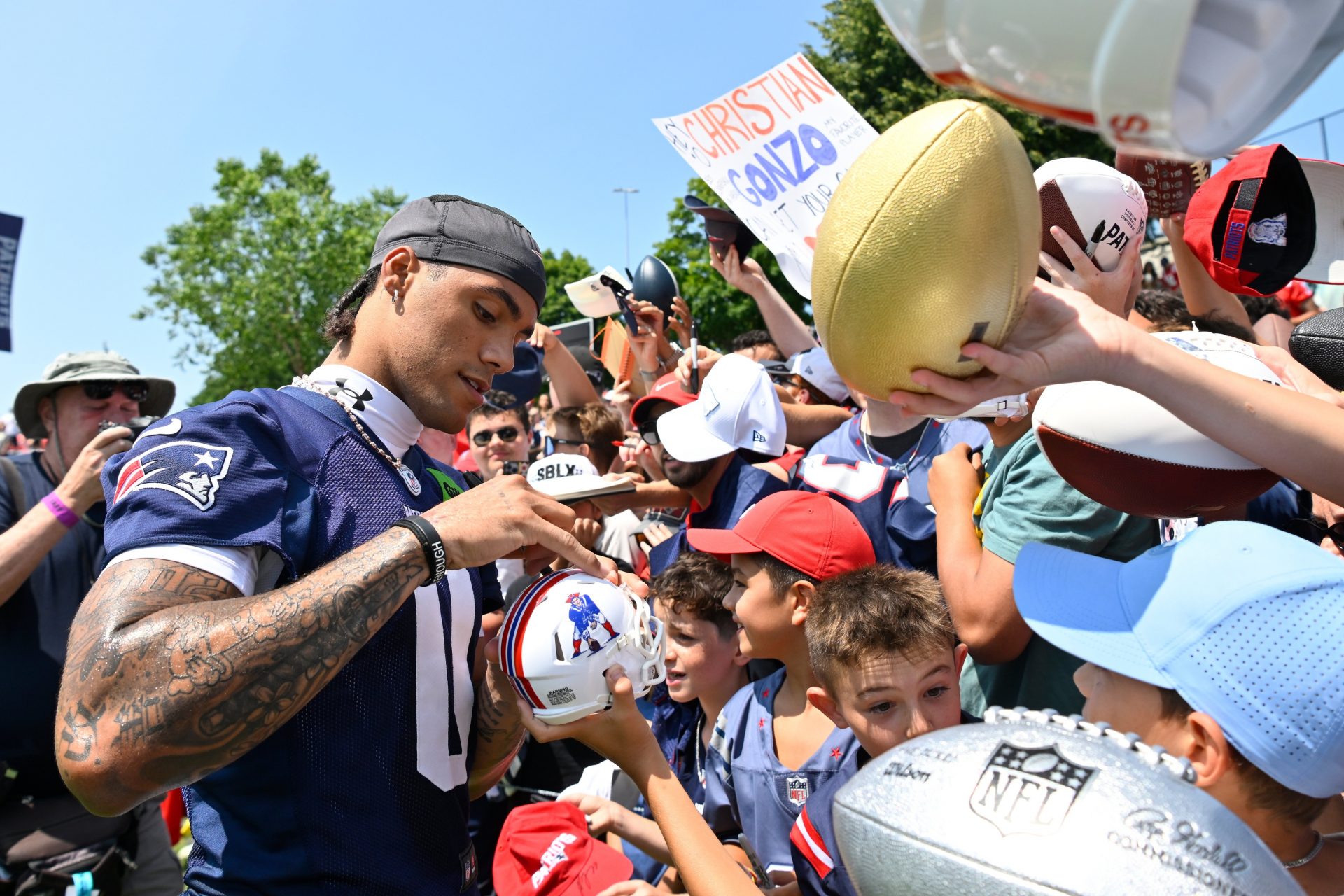 New England Patriots cornerback Christian Gonzalez (0) signs autographs after training camp at Gillette Stadium.