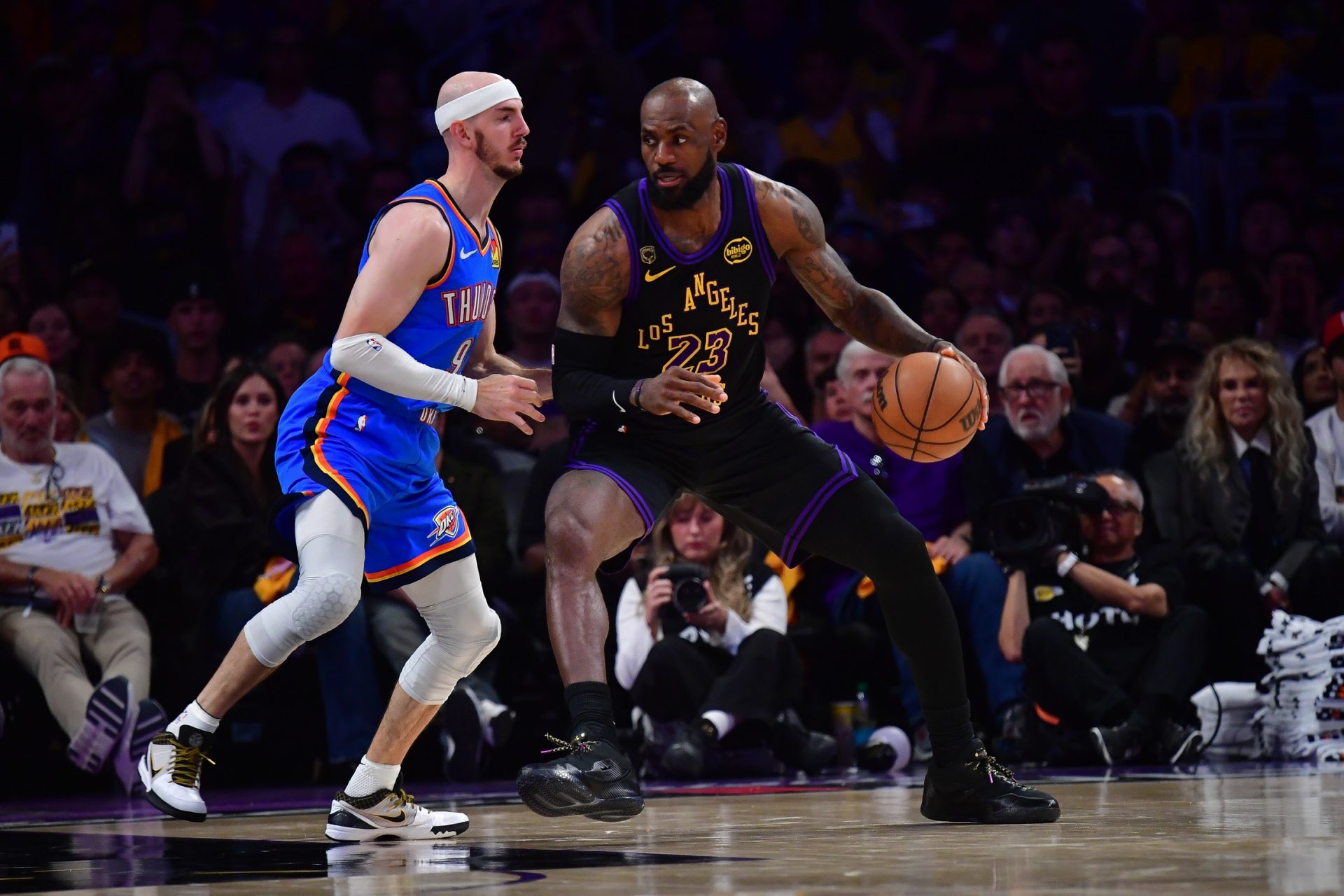 Los Angeles Lakers forward LeBron James (23) moves the ball against Oklahoma City Thunder guard Alex Caruso (9) during the second half in game four of the second round of the 2026 NBA Playoffs at Crypto.com Arena.
