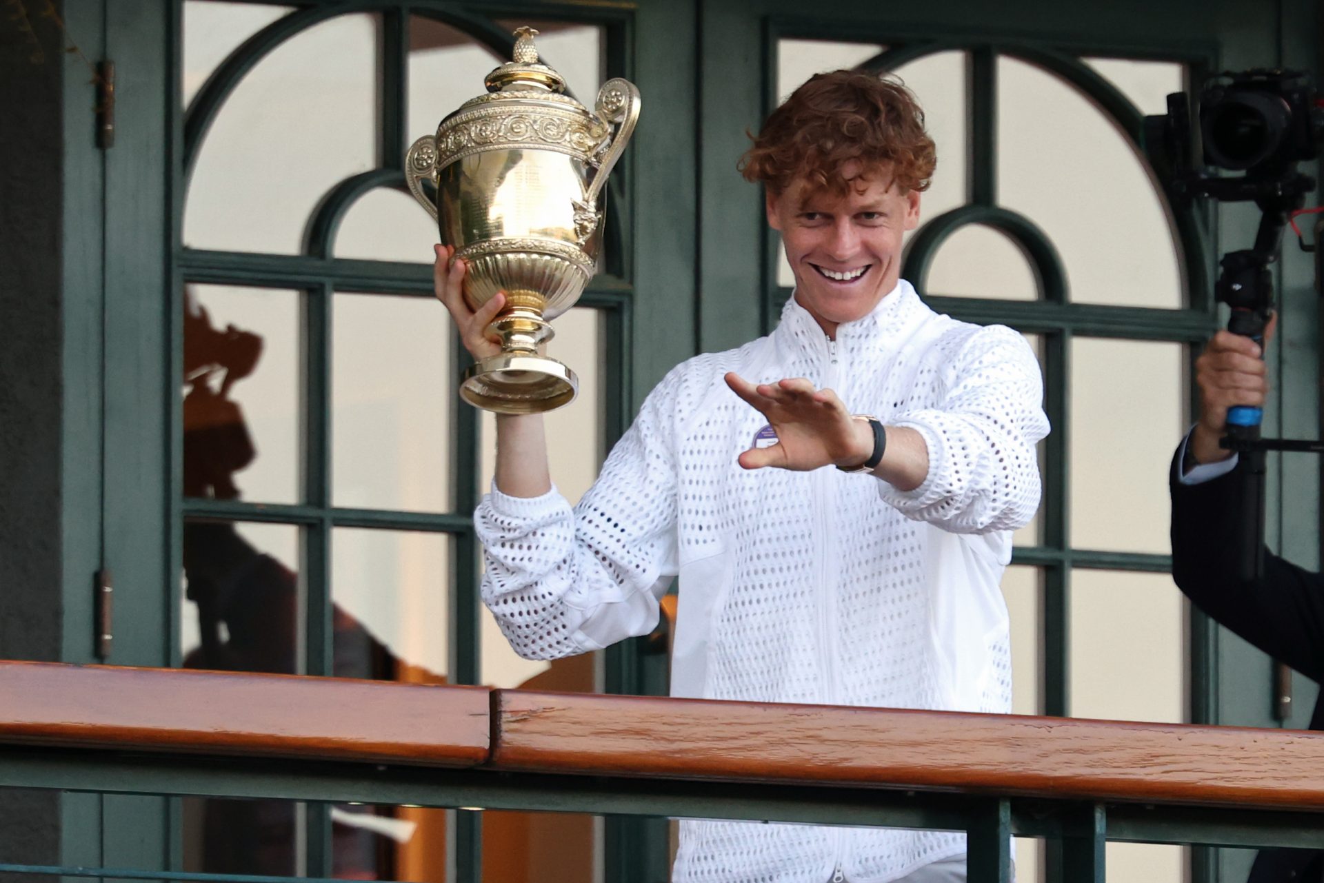 Jannik Sinner (ITA) holds the gentlemen's singles championship trophy on the South West Hall Balcony of Centre Court after the gentlemen's singles final of The Championships Wimbledon 2026 at All England Lawn Tennis and Croquet Club.