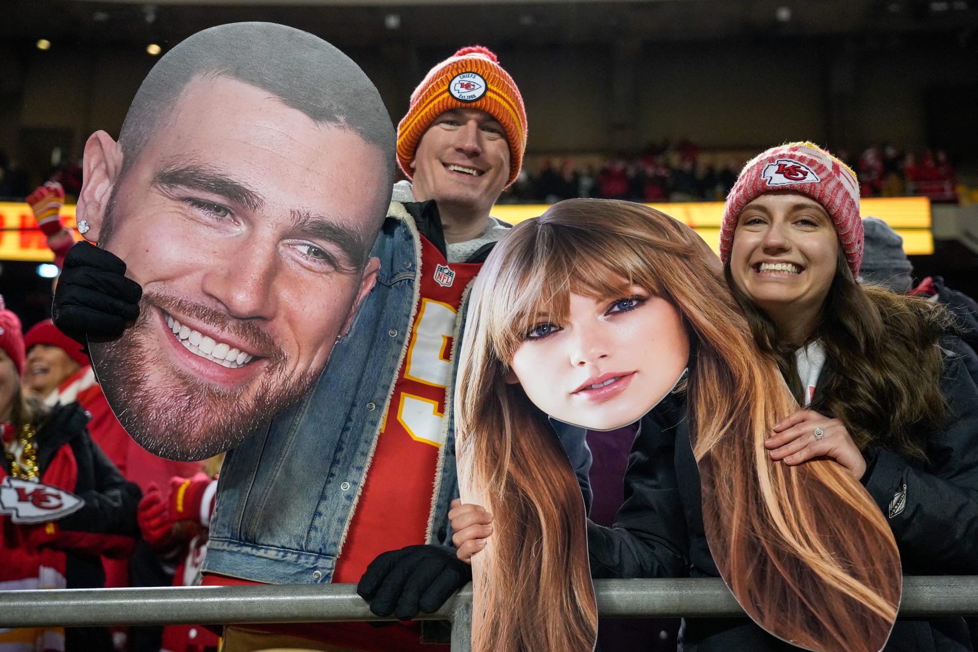 Chiefs fans wave Taylor Swift and Travis Kelce cutouts at Arrowhead Stadium. Credit: Imagn