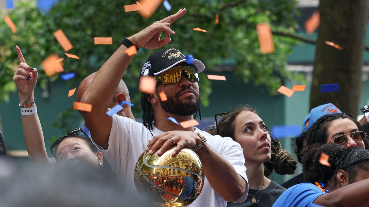 New York Knicks guard Jalen Brunson (11) celebrates while holding the Larry O'Brien Championship Trophy during the Knicks ticker-tape parade and celebration - Source: Imagn Images