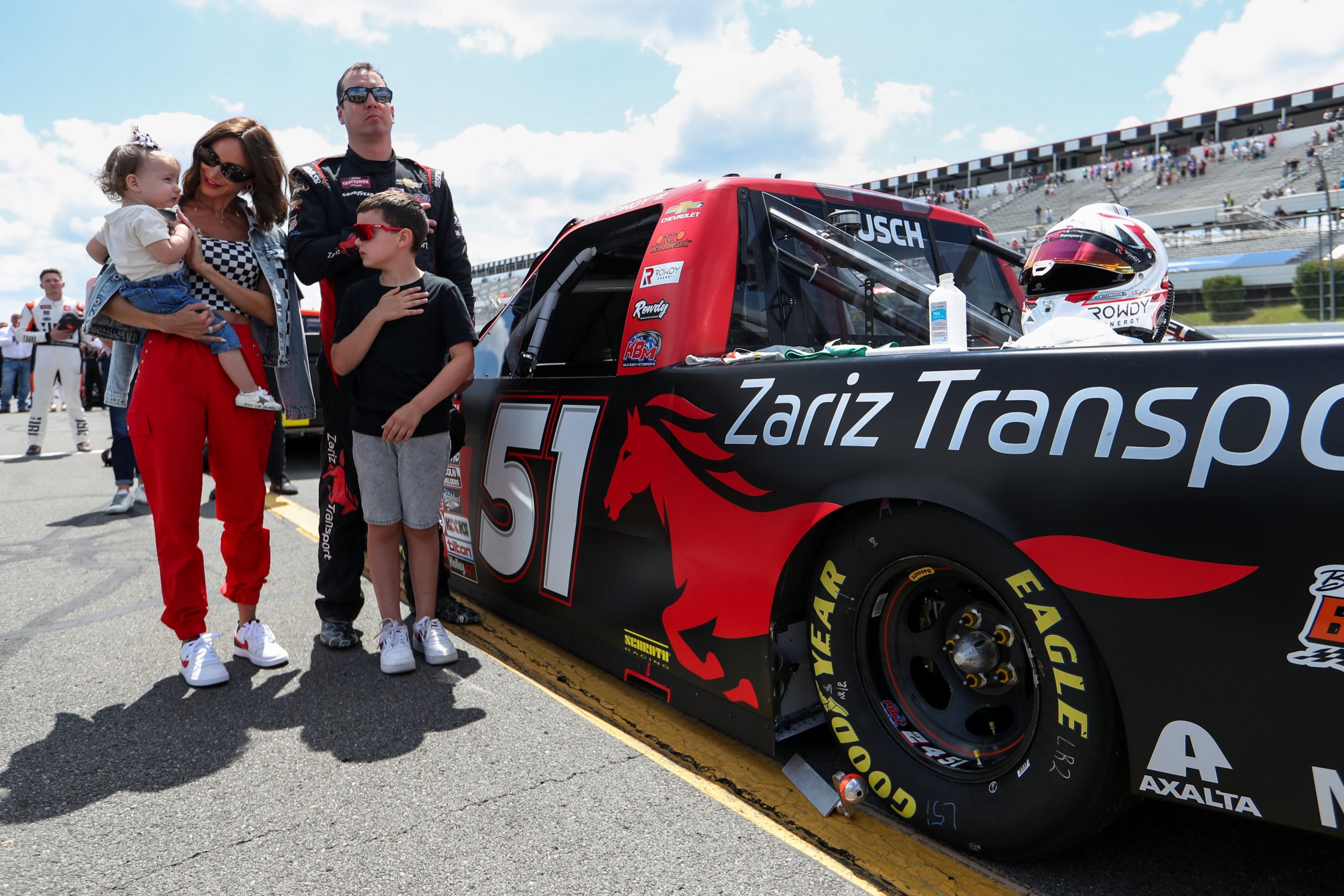 Jul 22, 2023; Long Pond, Pennsylvania, USA; NASCAR Craftsman Truck Series driver Kyle Busch stands with his wife Samantha Busch and children Brexton and Lennix prior to the CRC Brakleen 150 at Pocono Raceway. Mandatory Credit: Matthew O'Haren-USA TODAY Sports