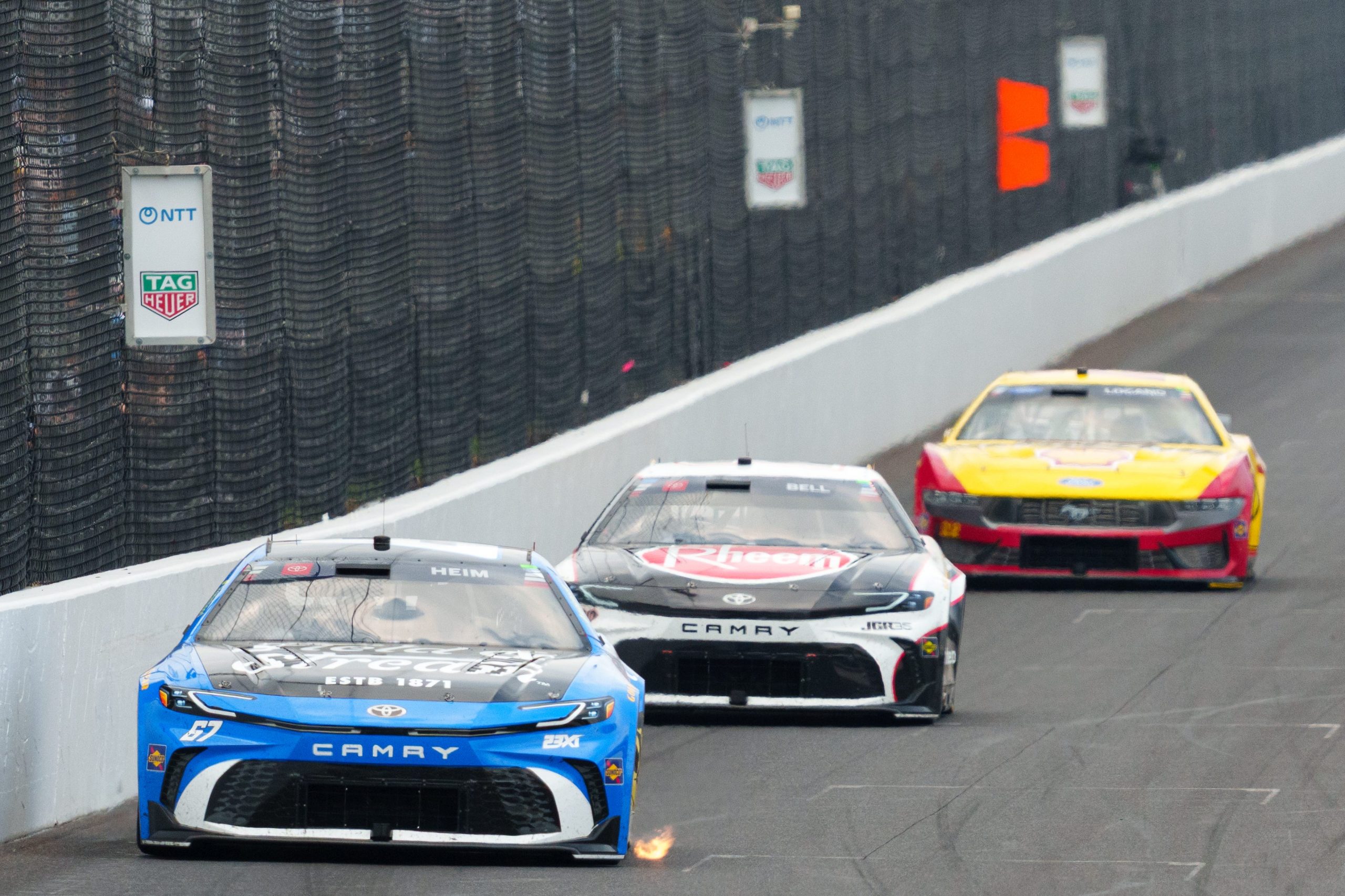NASCAR Cup Series driver Corey Heim (67) leads Sunday, July 26, 2026, during the Brickyard 400 at Indianapolis Motor Speedway. Christopher Bell and Joey Logano trail closeby.