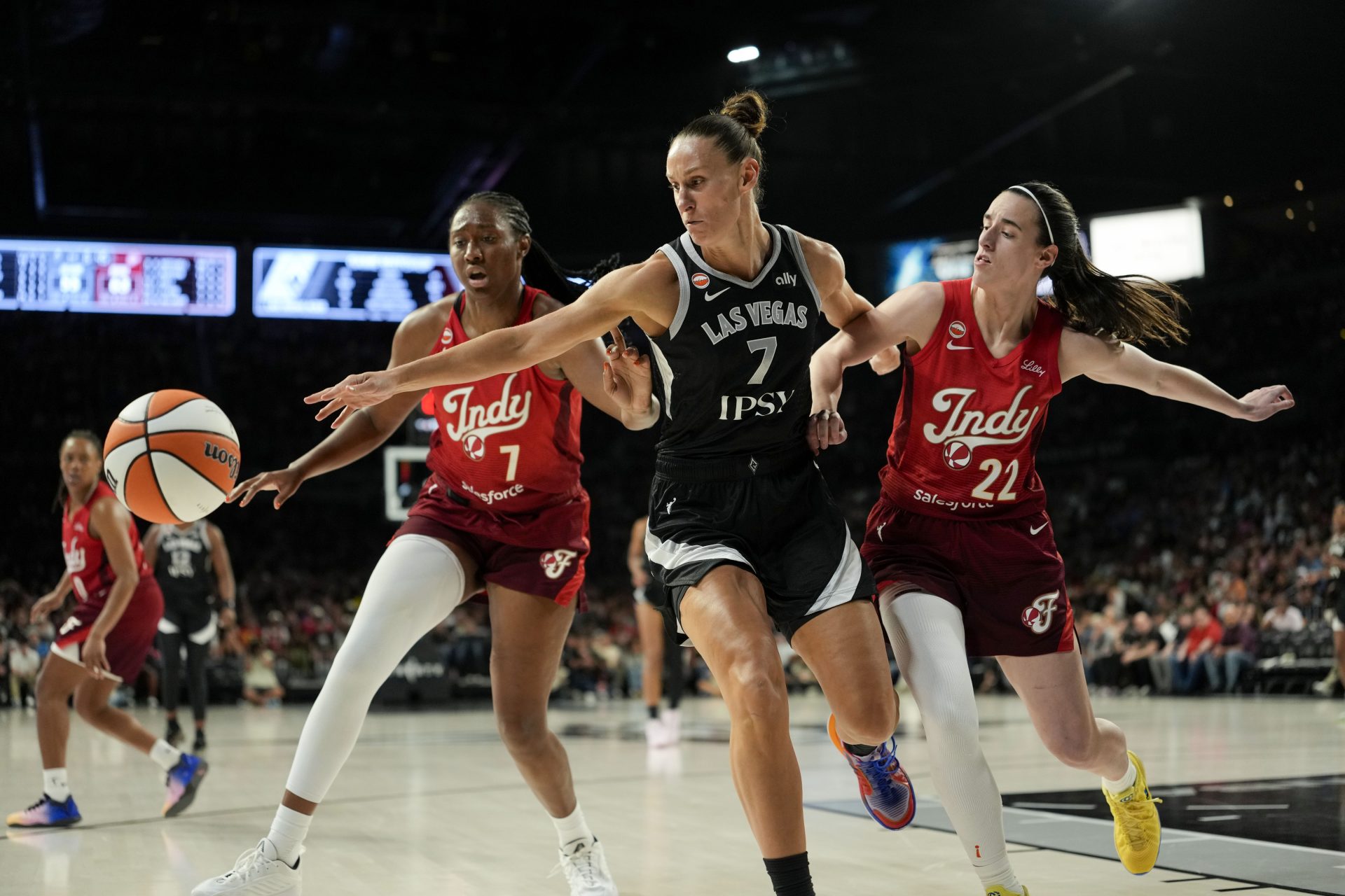 Las Vegas Aces forward Stephanie Talbot (7) reaches for the ball against Indiana Fever center-forward Aliyah Boston (7) and guard Caitlin Clark (22) during the third quarter of a WNBA basketball game at Michelob Ultra Arena.