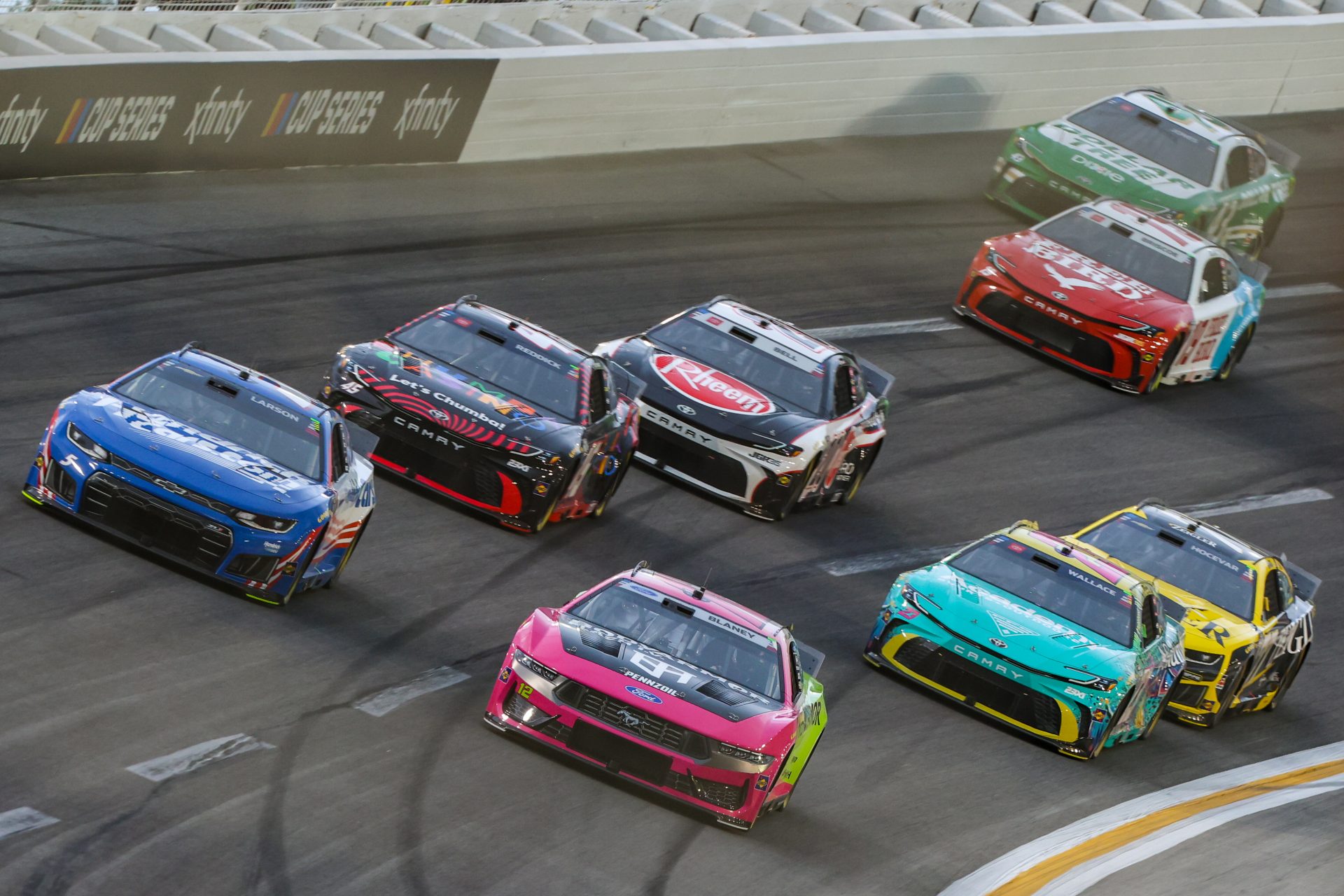 HendrickCars.com driver Kyle Larson (5), Body Armor Flash I.V. driver Ryan Blaney (12), Chumba Casino driver Tyler Reddick (45), Columbia PFG/Academy Sports driver Bubba Wallace (23), Rheem driver Christopher Bell (20), Zeigler Auto Group driver Carson Hocevar (77), Freebird Spring Water driver Chase Briscoe (19), and Dollar Tree driver Erik Jones (43) race during the Quaker State 400 at EchoPark Speedway.