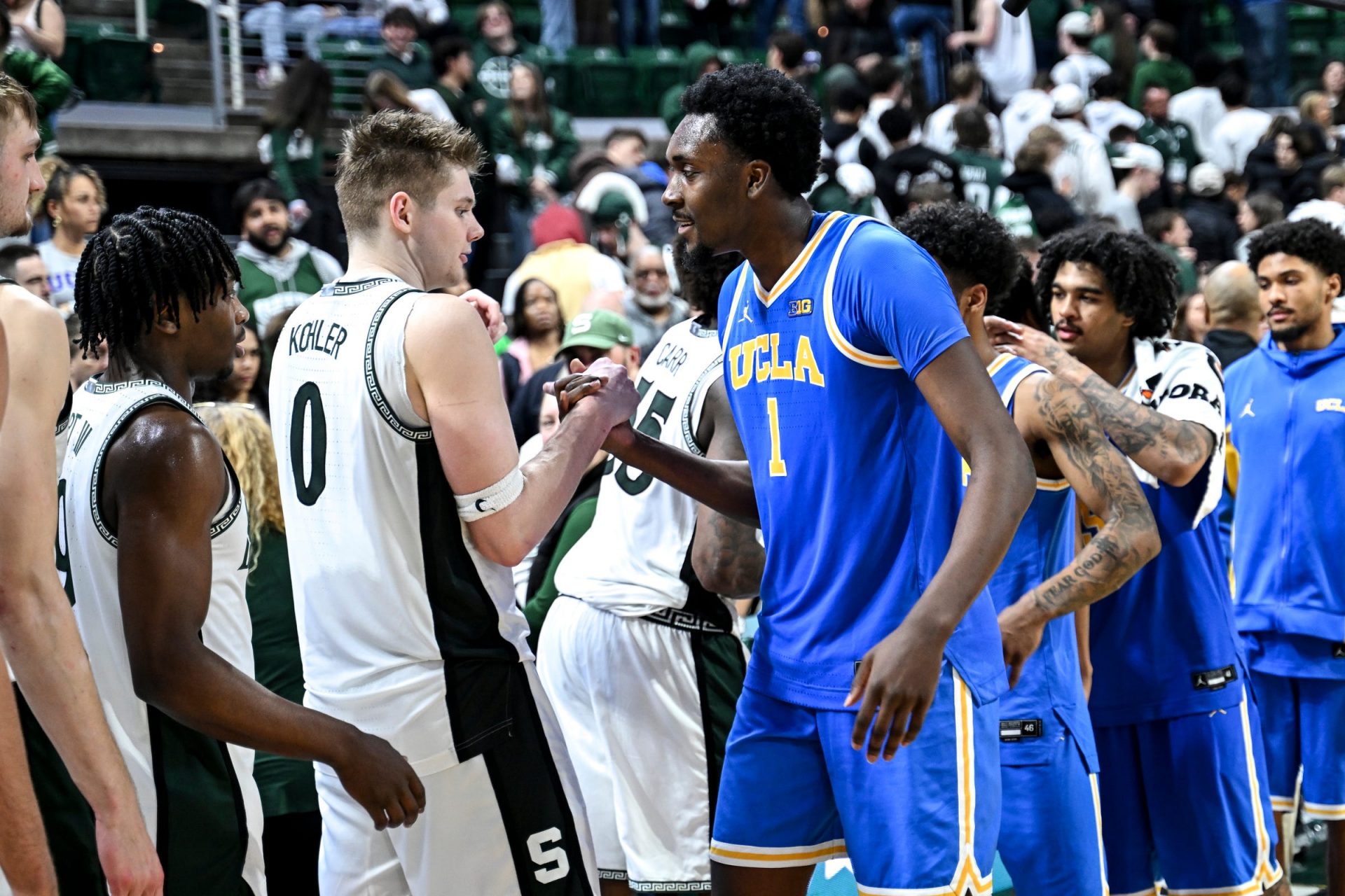 Michigan State's Jaxon Kohler, left, shakes hands with former teammate UCLA's Xavier Booker after the game on Tuesday, Feb. 17, 2026, at the Breslin Center in East Lansing. Credit: Imagn