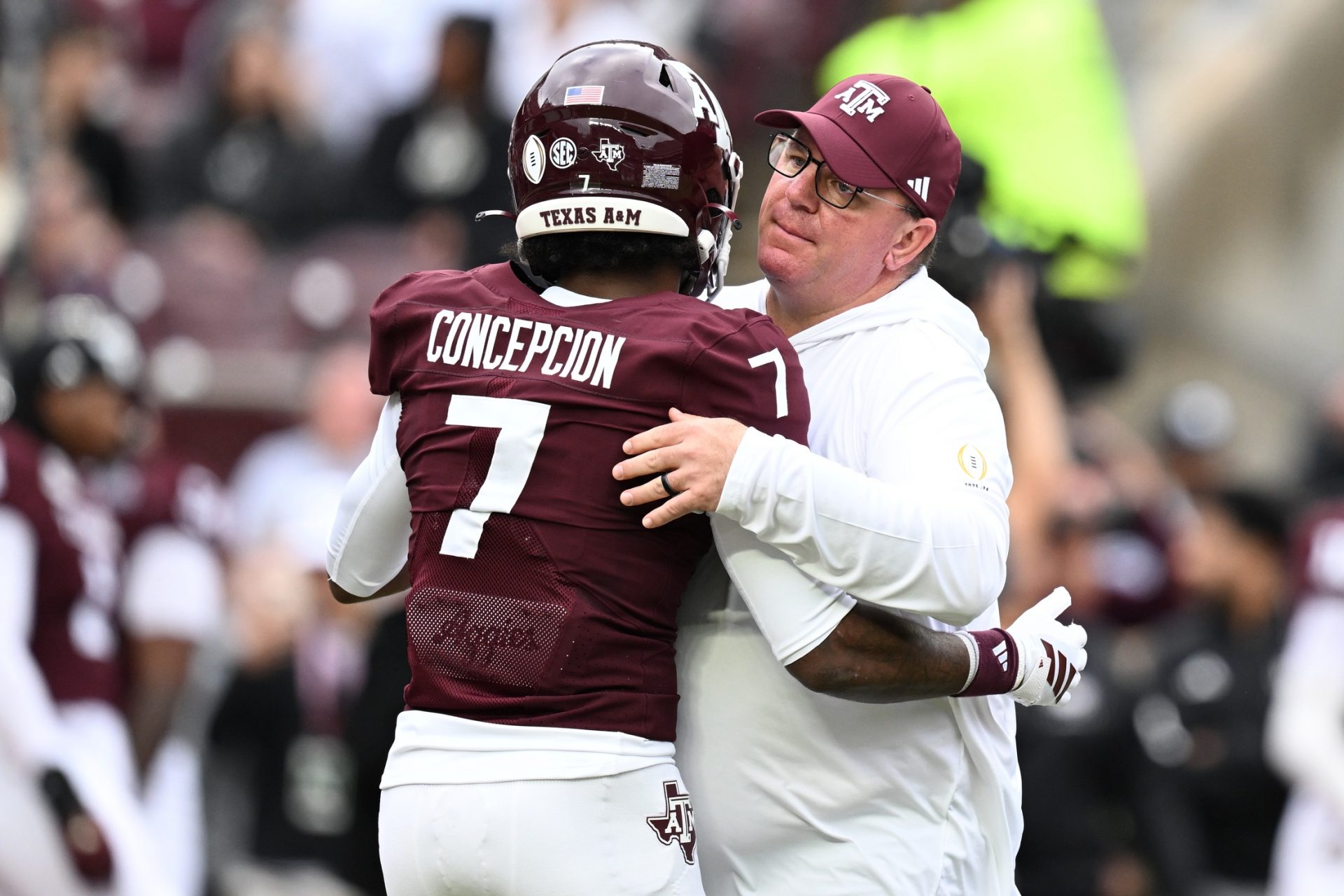 exas A&M Aggies head coach Mike Elko hugs Texas A&M Aggies wide receiver KC Concepcion (7) prior to the game against the Miami Hurricanes during the first round of the CFP National Playoff at Kyle Field. 
Source: Imagn