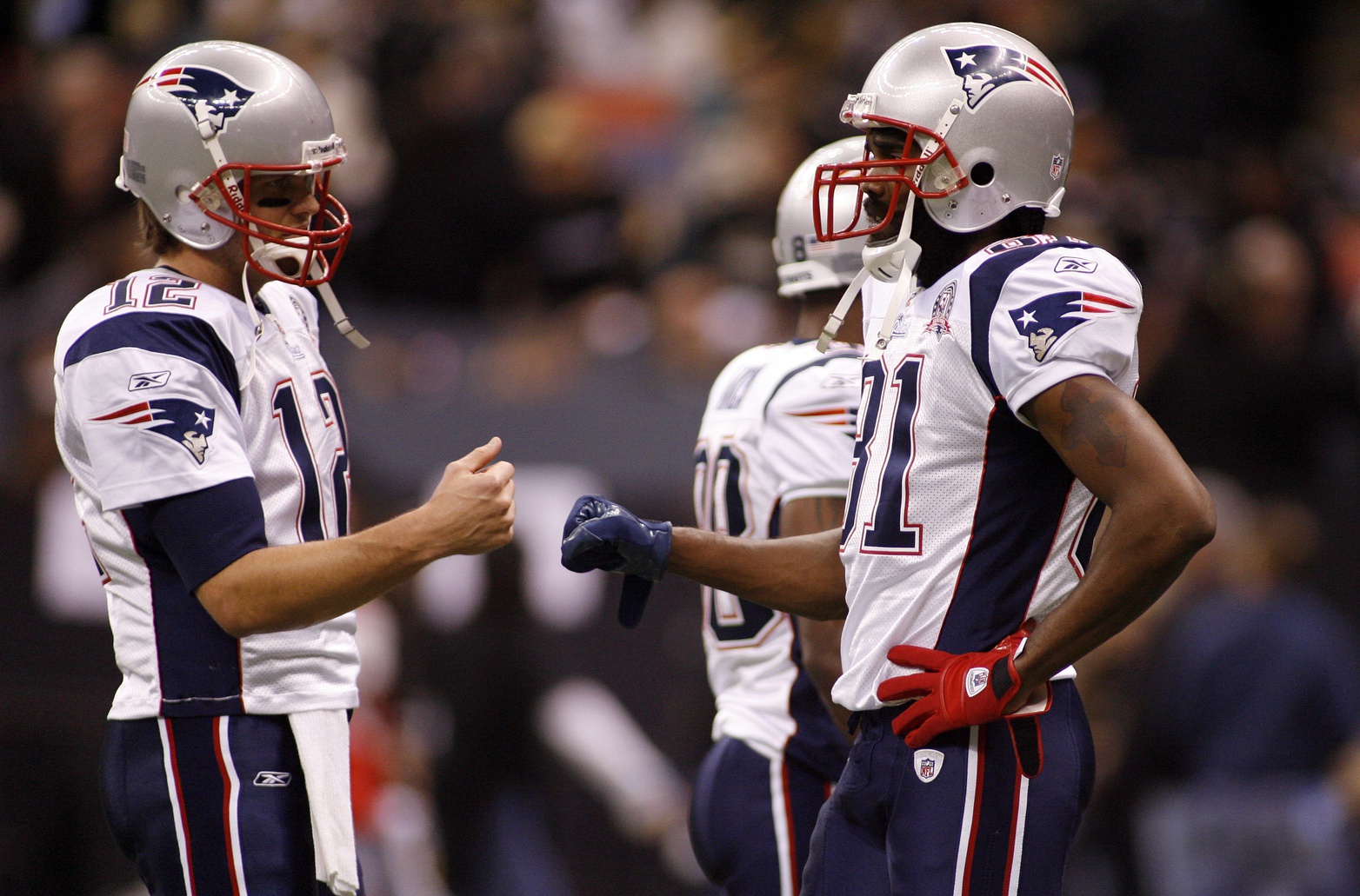 New England Patriots quarterback Tom Brady (12) bump fists with wide receiver Randy Moss (81) during pregame warmups against the New Orleans Saints at the Louisiana Superdome. Source: Imagn