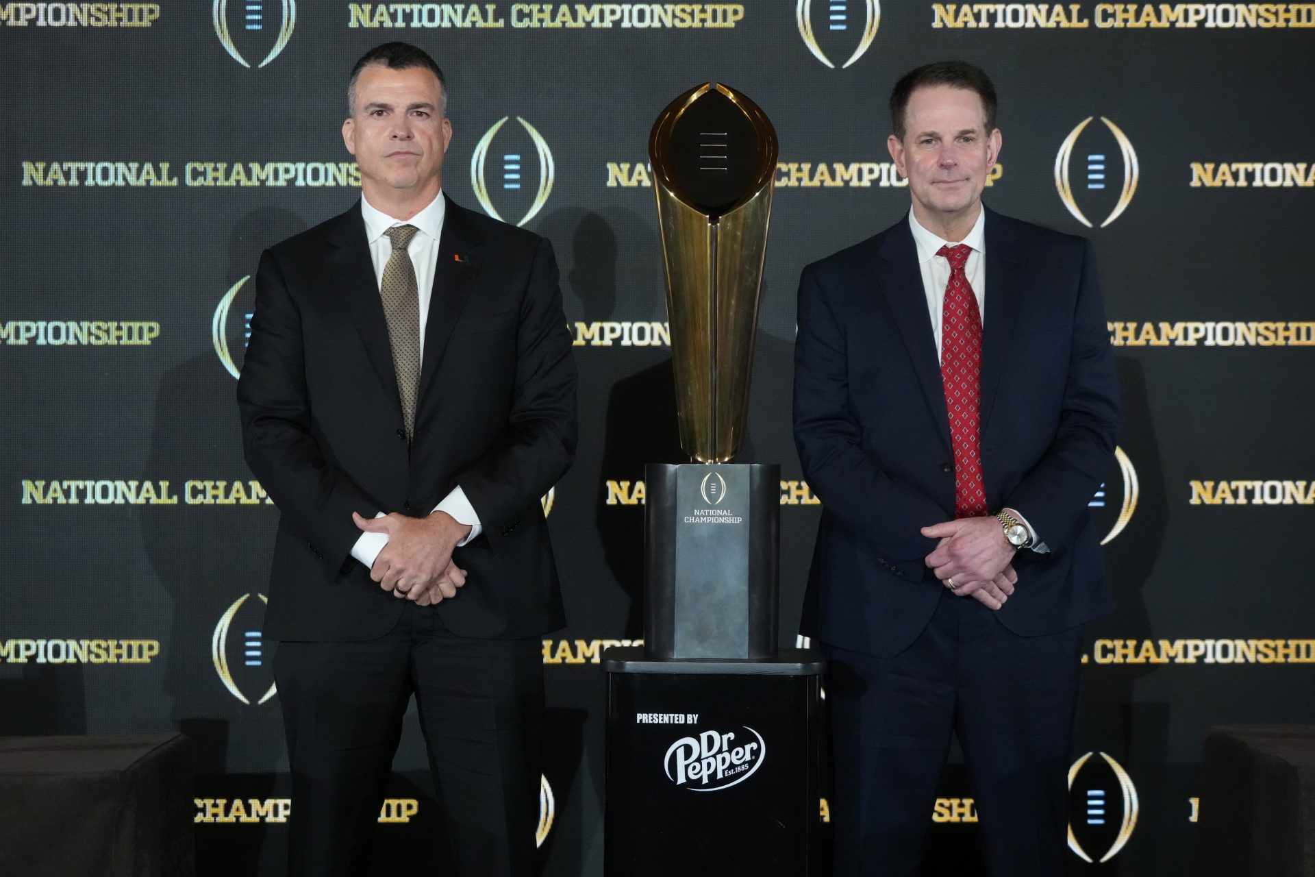 Miami Hurricanes coach Mario Cristobal (left) and Indiana Hoosiers coach Curt Cignetti pose with the national championship trophy during the CFP head coaches press conference at JW Marriott Marquis Miami.